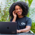 mulher morena trabalhando home office camisa preta